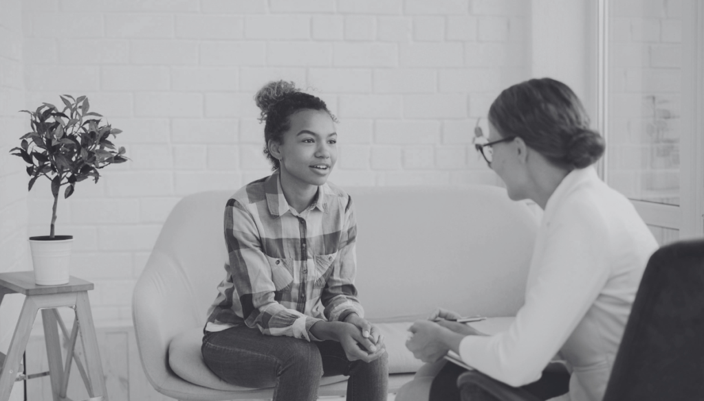 A woman therapist sitting with a young woman